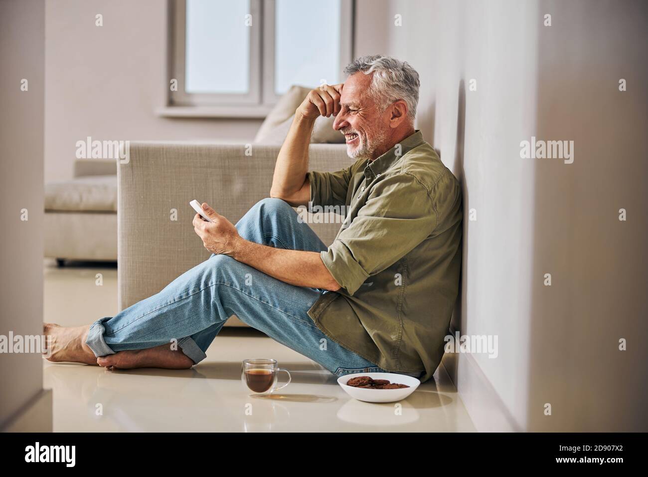 Elderly man sitting on the floor smiling hi-res stock photography and ...