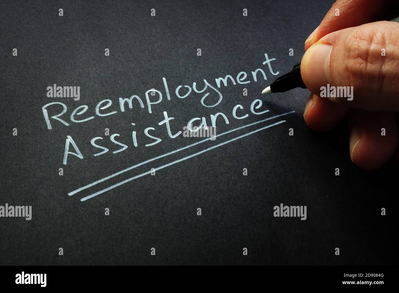 Reemployment assistance handwritten words by white pen. Stock Photo