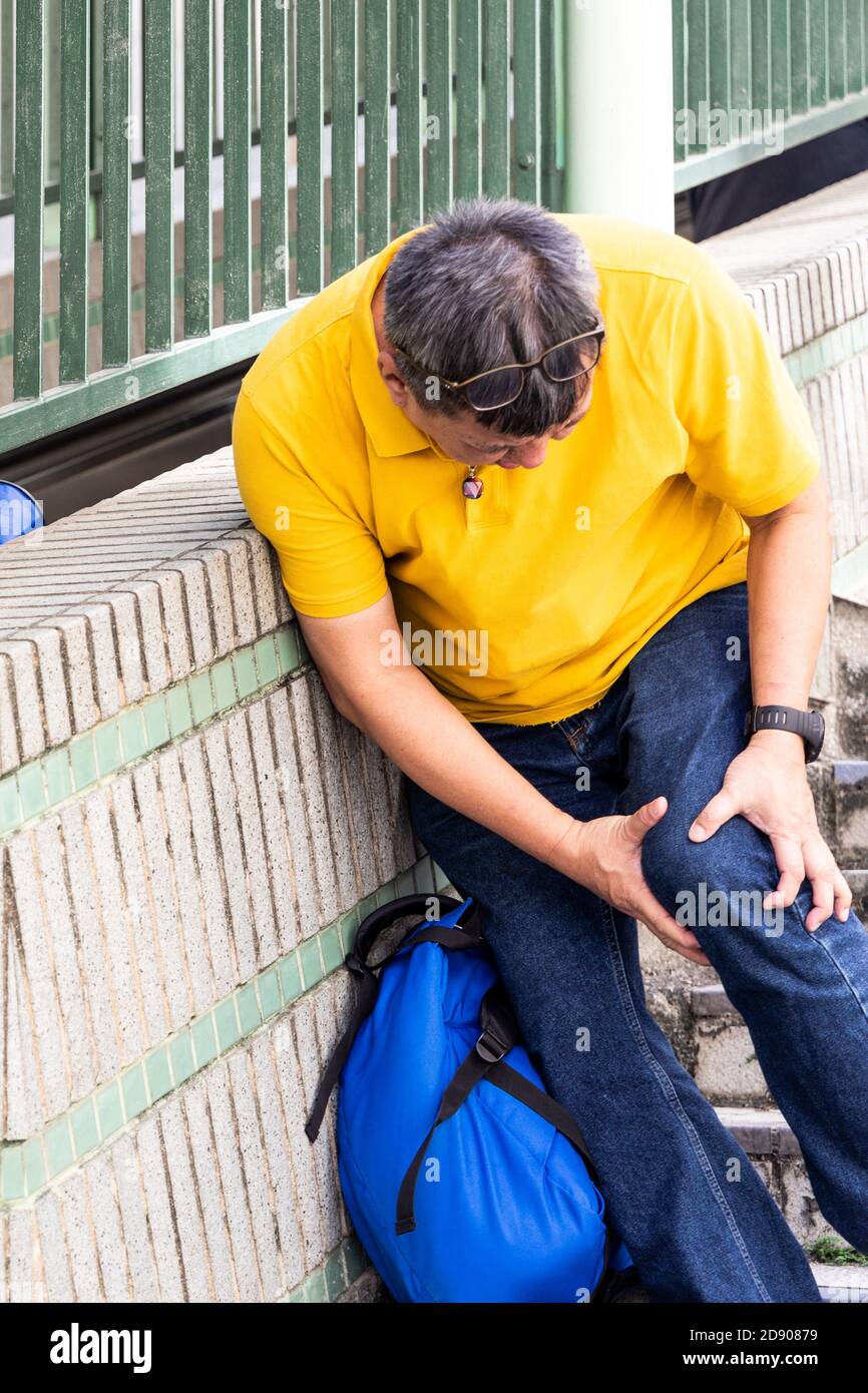 Man with painful knee struggle walking down flight of stairs Stock Photo Alamy