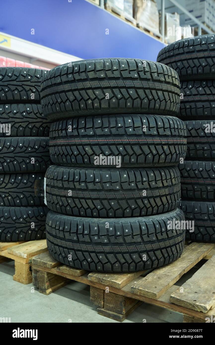 New winter car tires lie on the pallet in a store Stock Photo