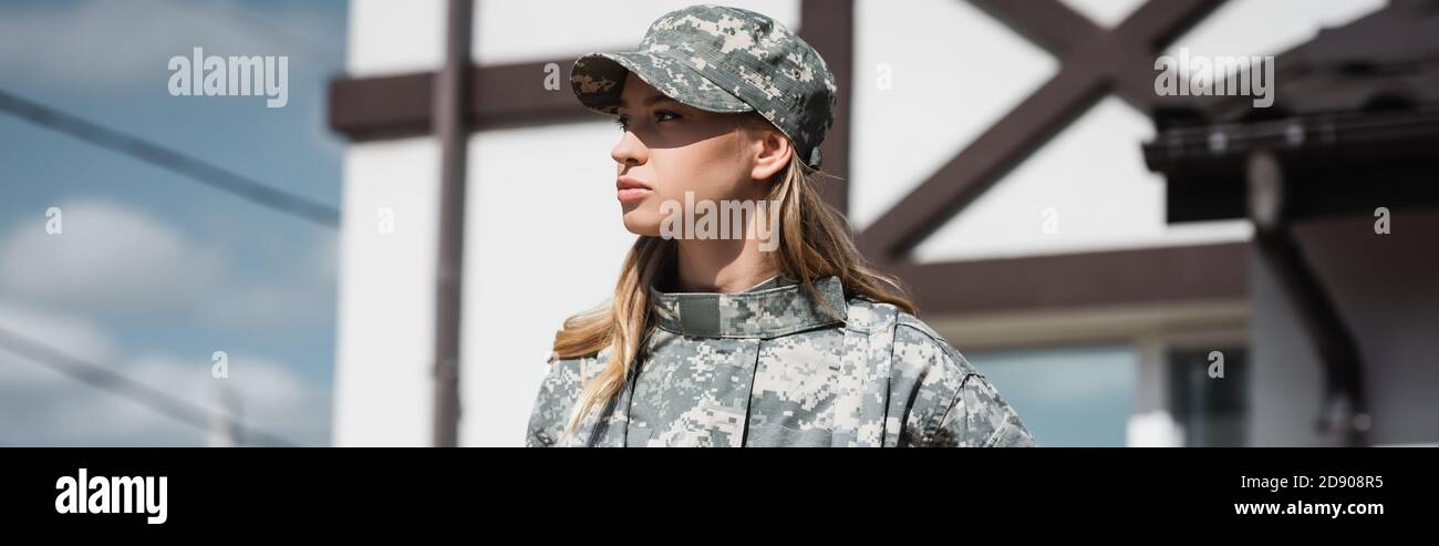 Confident military servicewoman looking away on blurred background, banner Stock Photo
