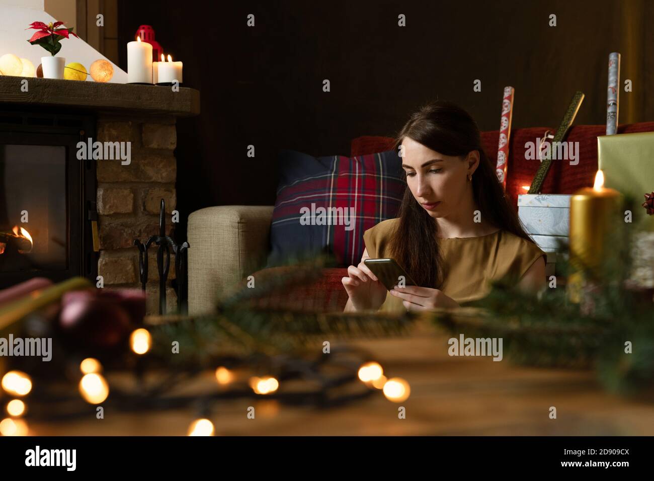Gift workshop in a warm cozy room. Christmas decorations by fireplace. Stock Photo