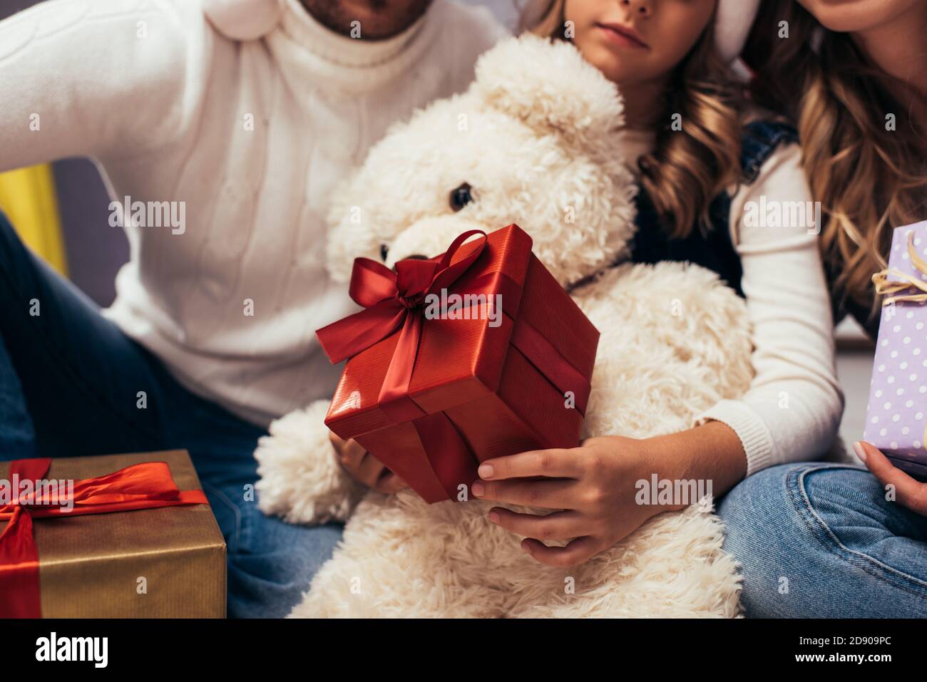 cropped view of kid holding christmas presents near parents Stock Photo