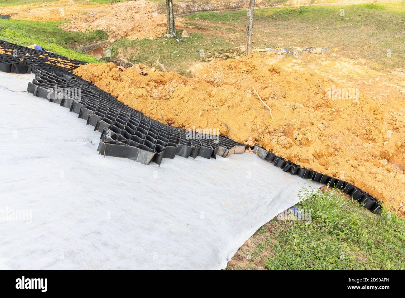 Slope erosion control grids, sheets and earth on steep slope Stock