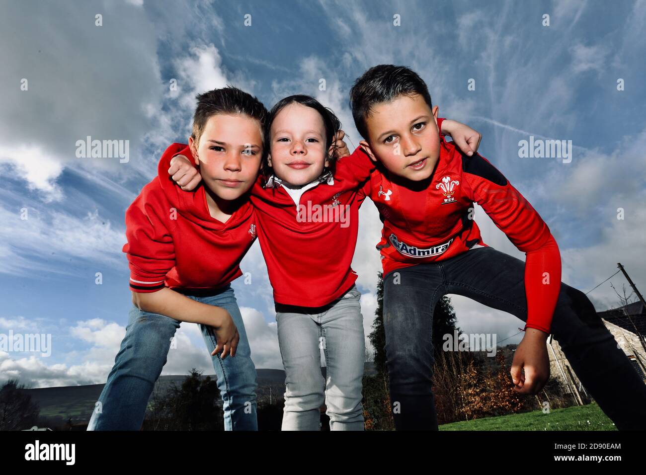 Three young Welsh rugby fans scrum down on St Davids Day in the sunshine. Crickhowell, powys, South Wales, March the 5th 2019. ©PRWPhotography Stock Photo