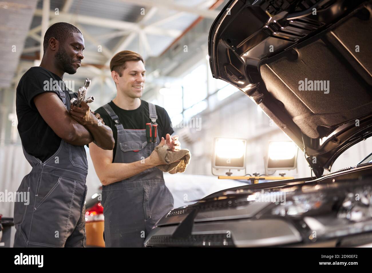 two friendly professional auto mechanic during work, they are