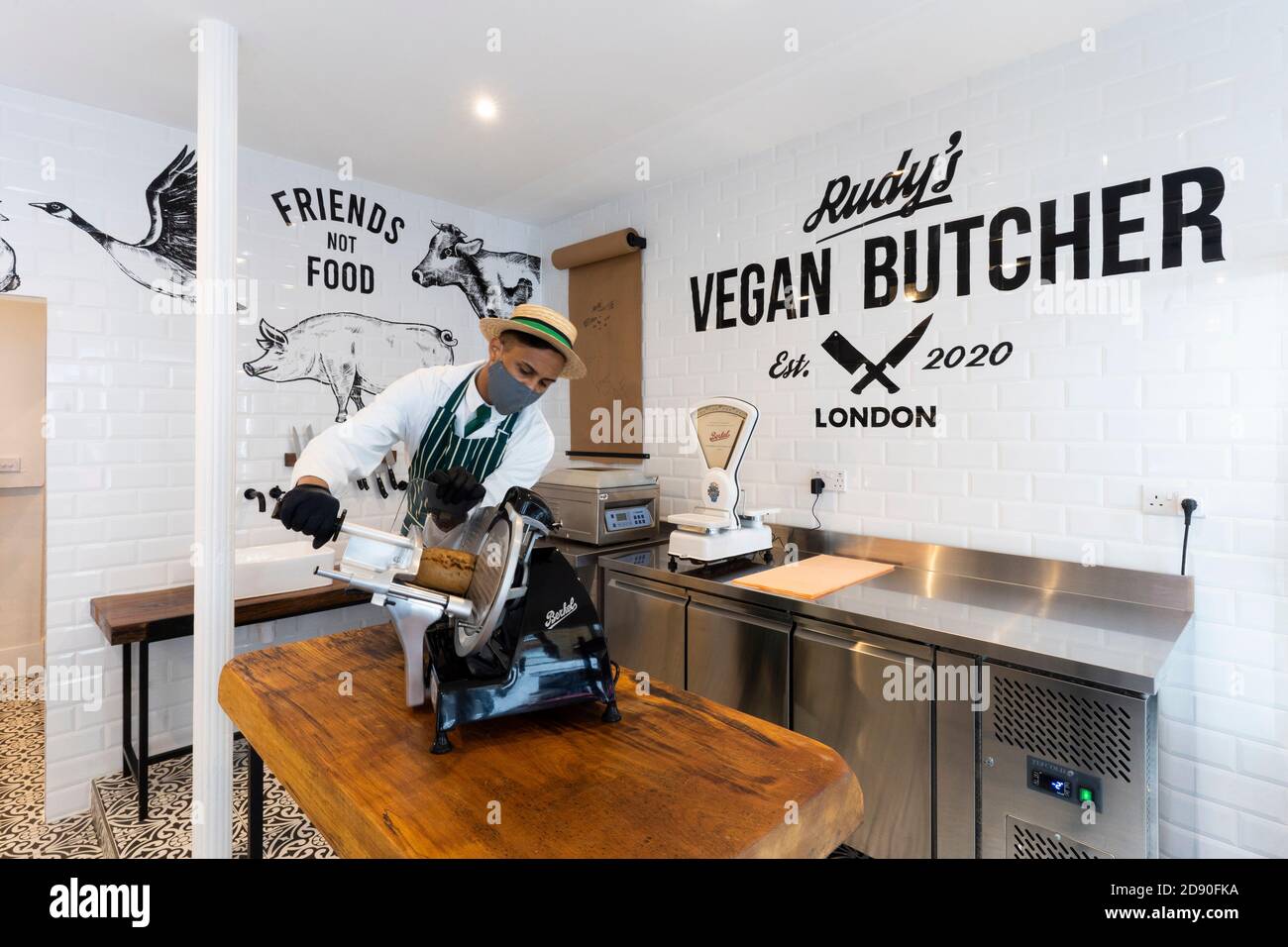 Rudys Vegan Butcher delicatessen opens in Islington London.  Picture shows 'butcher' sliceing meat substitute, wearing face mask. Stock Photo