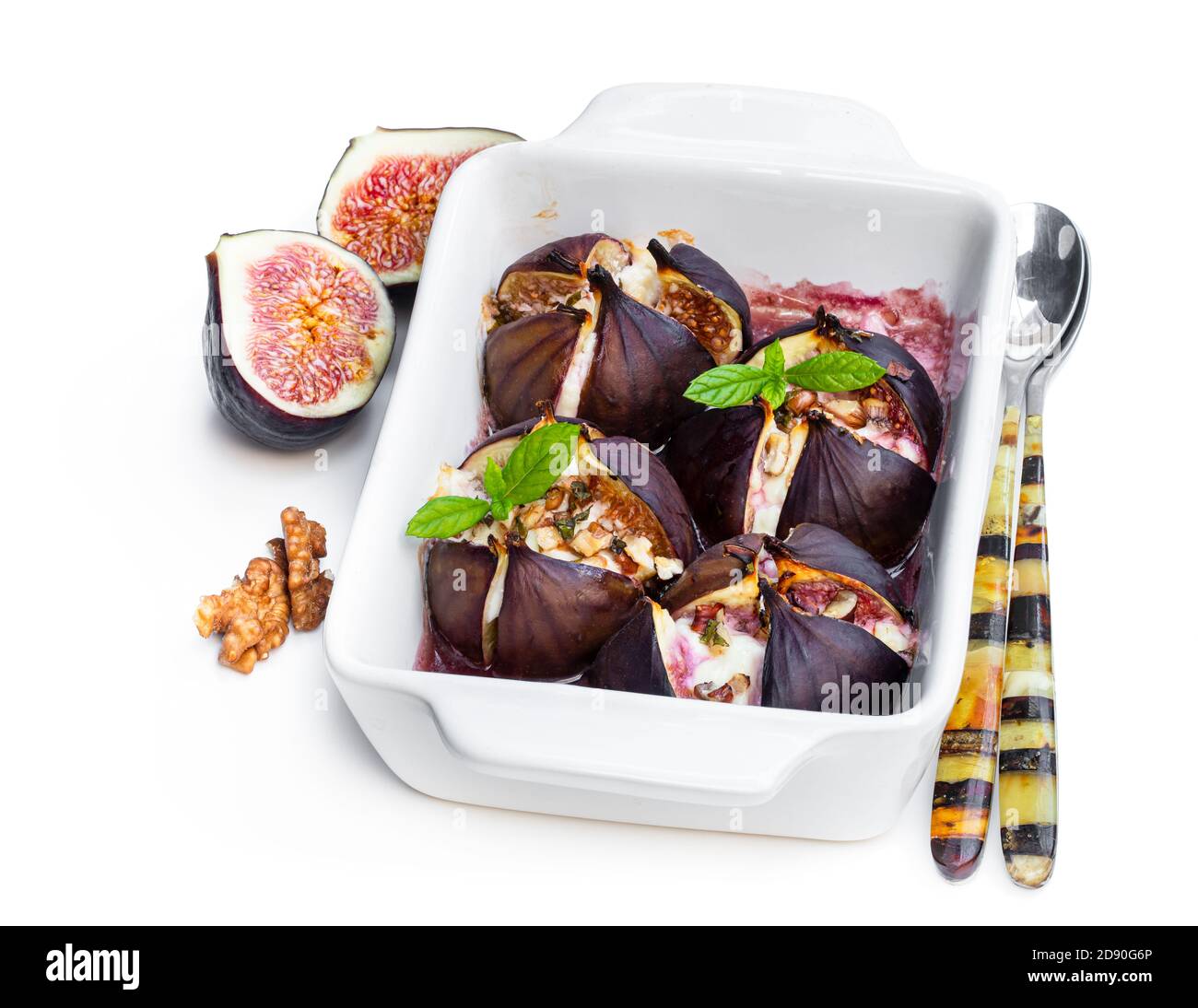 Baked figs with goat cheese and walnuts with honey isolated on white
