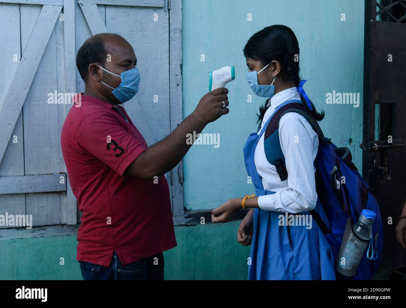 Guwahati, Assam, India. 2nd November, 2020. Employee thermal screening a student before attend a class, after schools re-opened following a gap of more than seven months due to coronavirus pandemic, in Guwahati, Assam, India on Nov. 2, 2020. Credit: David Talukdar/Alamy Live News Stock Photo