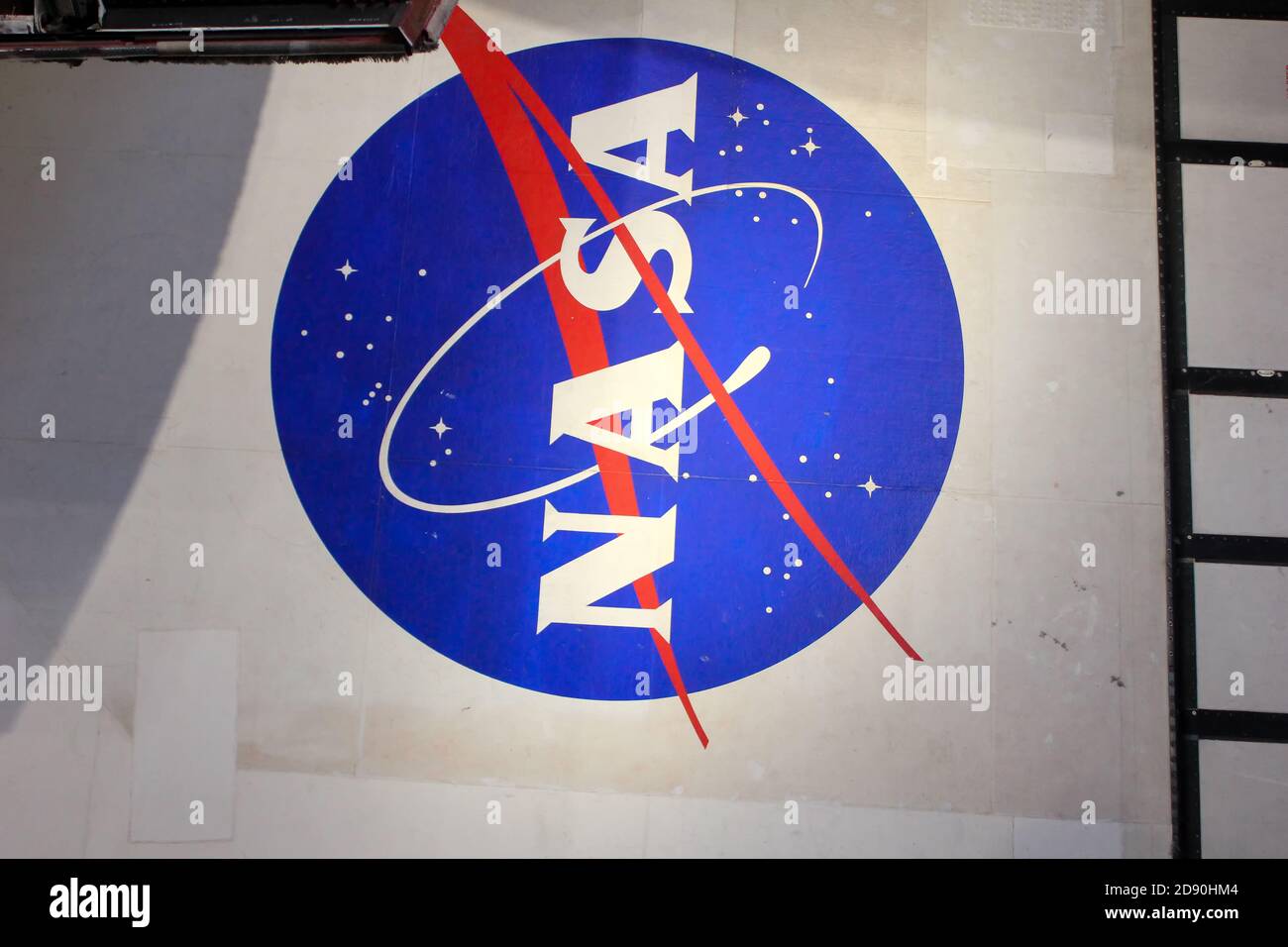 NASA Logo on Globe at Kennedy Space Center Visitor Complex in Cape Canaveral, Florida, USA. To the left is a painting visible of John F. Kennedy. Stock Photo