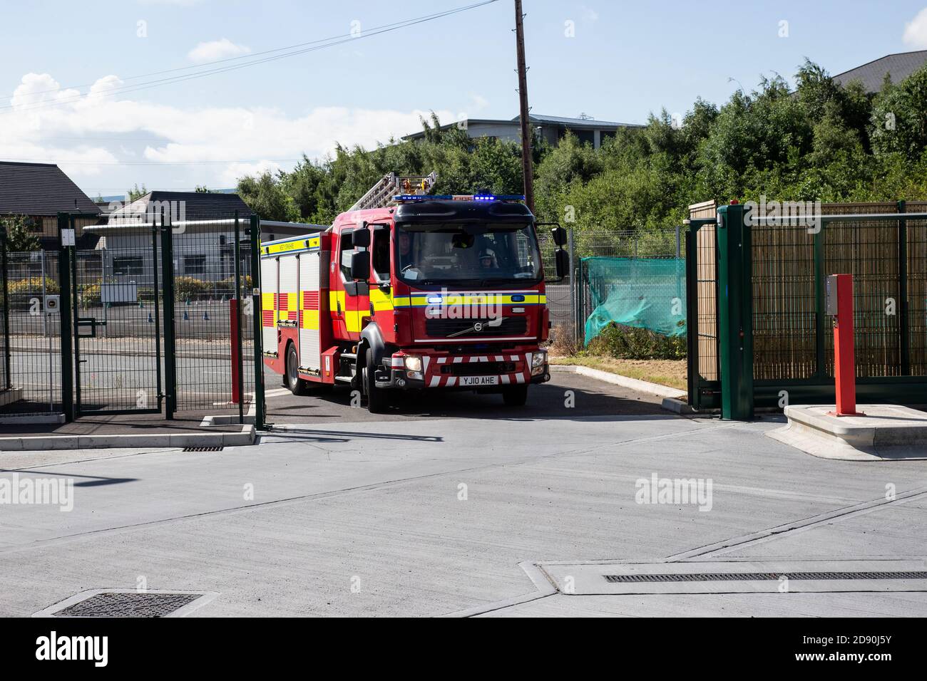 A fully equipped English fire engine leaving Ossett fire station in Wakefield West Yorkshire with its blue lights flashing and siren sounding Stock Photo
