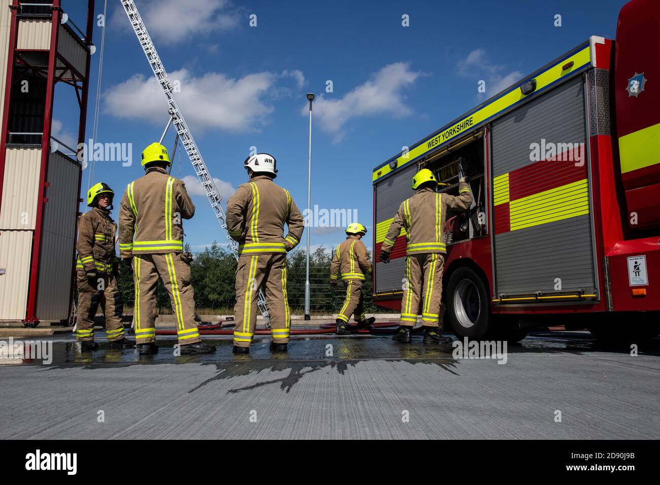 British firefighters undergoing a training session and checking firefighting equipment is fully operational at Ossett Fire Station, West Yorkshire UK Stock Photo