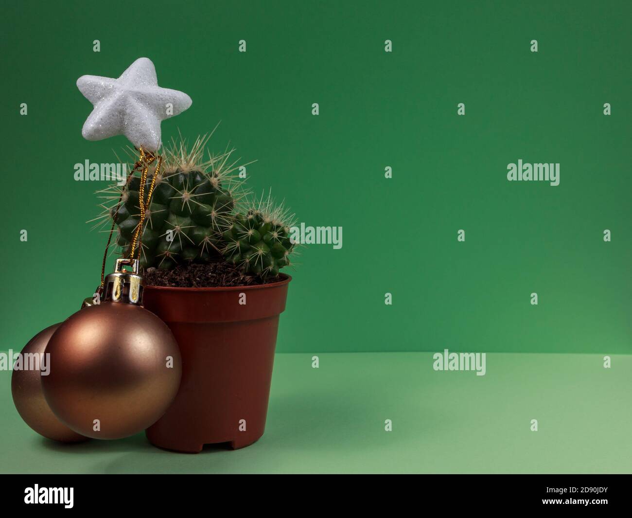 Creative cactus Christmas tree with decoration and white shiny tree star. Green background Stock Photo