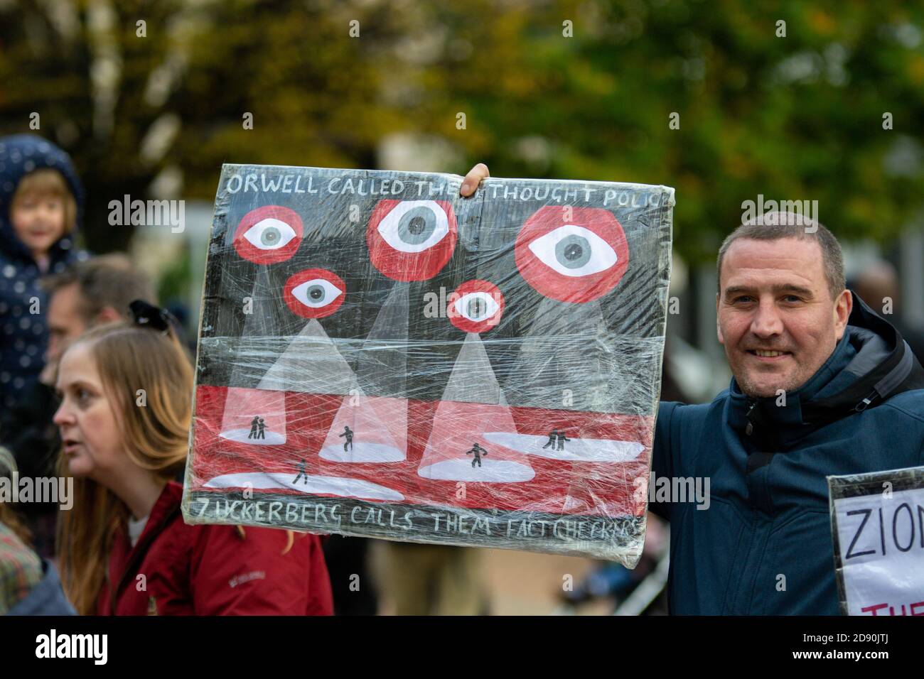 Man holds up sign comparing Facebook fact checkers to Orwellian ...