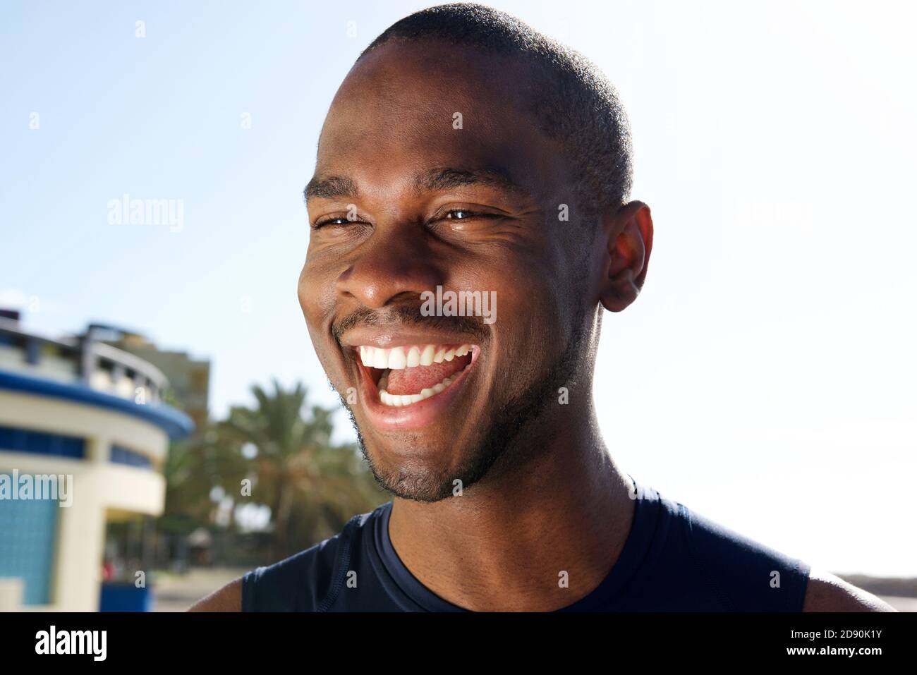 Close up portrait of handsome young black man laughing outdoors Stock ...
