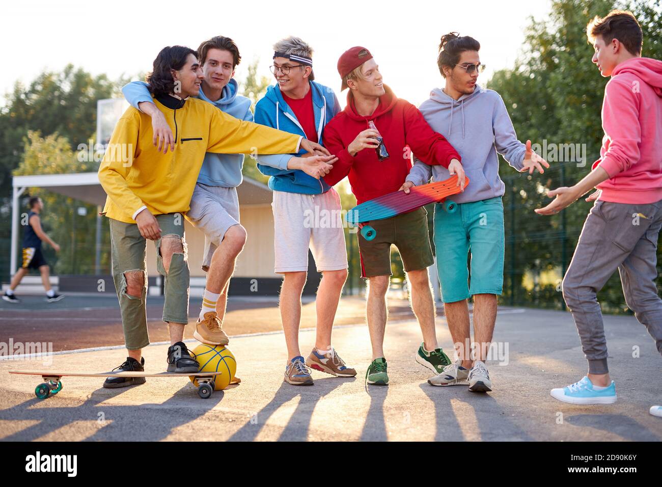 caucasian city teenagers have fun outdoors at sport playground, in the park. young boys in good mood, spend time together Stock Photo