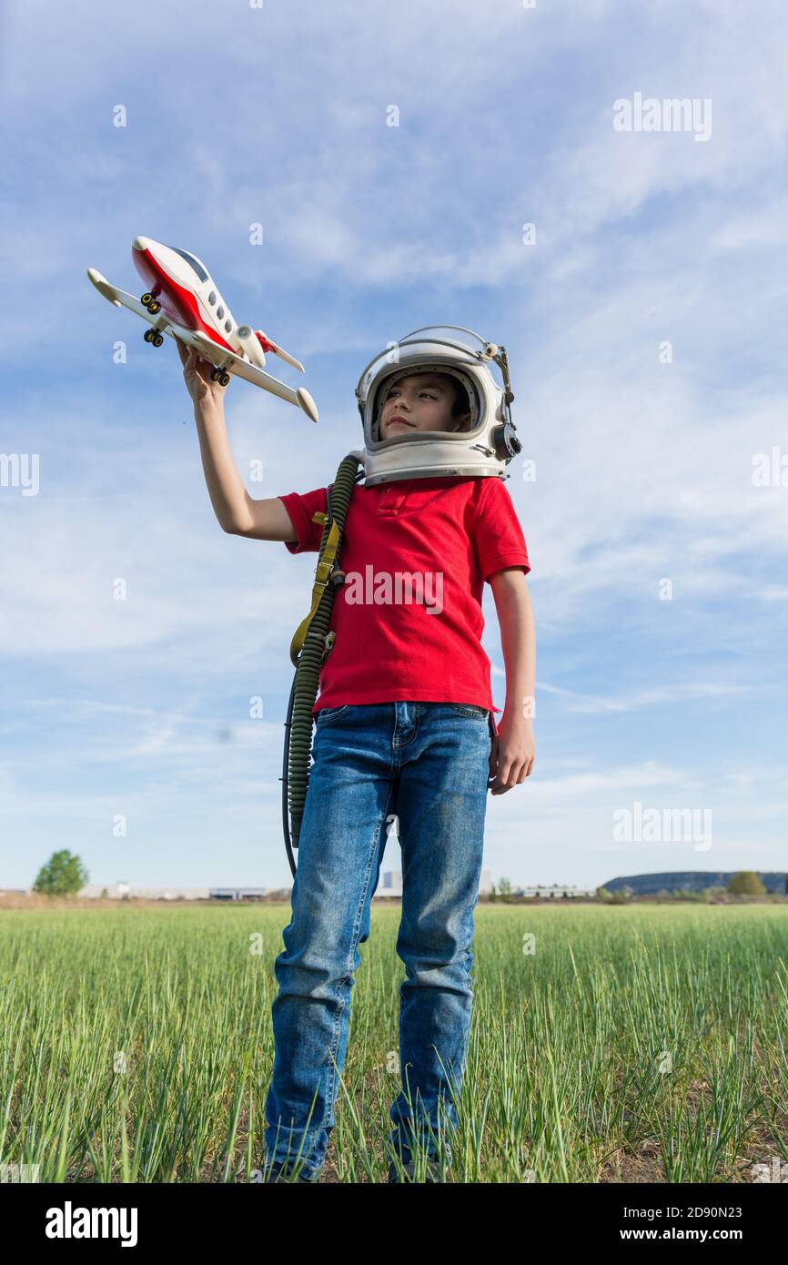 boy with astronaut helmet and plane, playing to be pilot Stock Photo ...