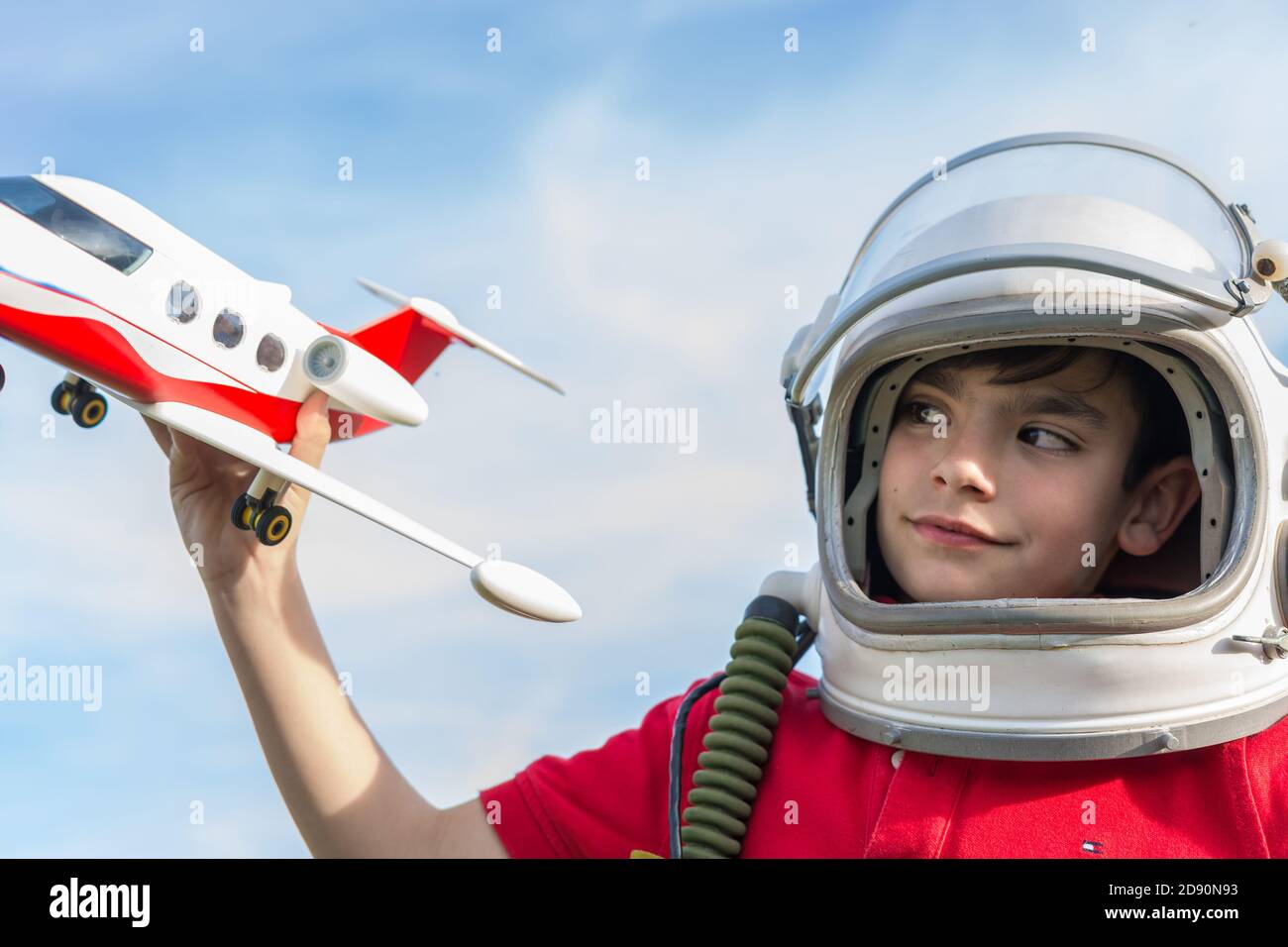 boy with astronaut helmet and plane, playing to be pilot Stock Photo