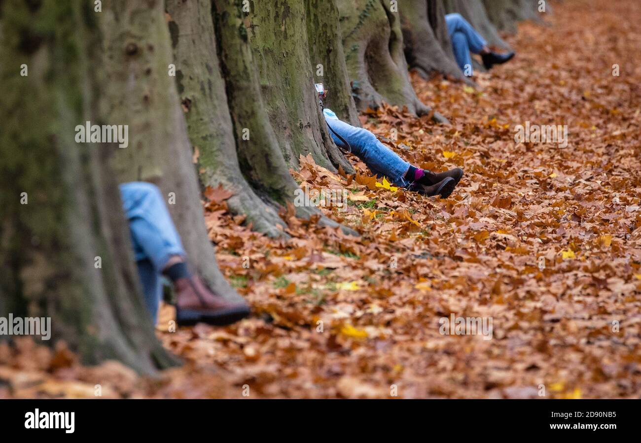 02 November 2020, BadenWuerttemberg, Tübingen In warm temperatures, people sit on the benches