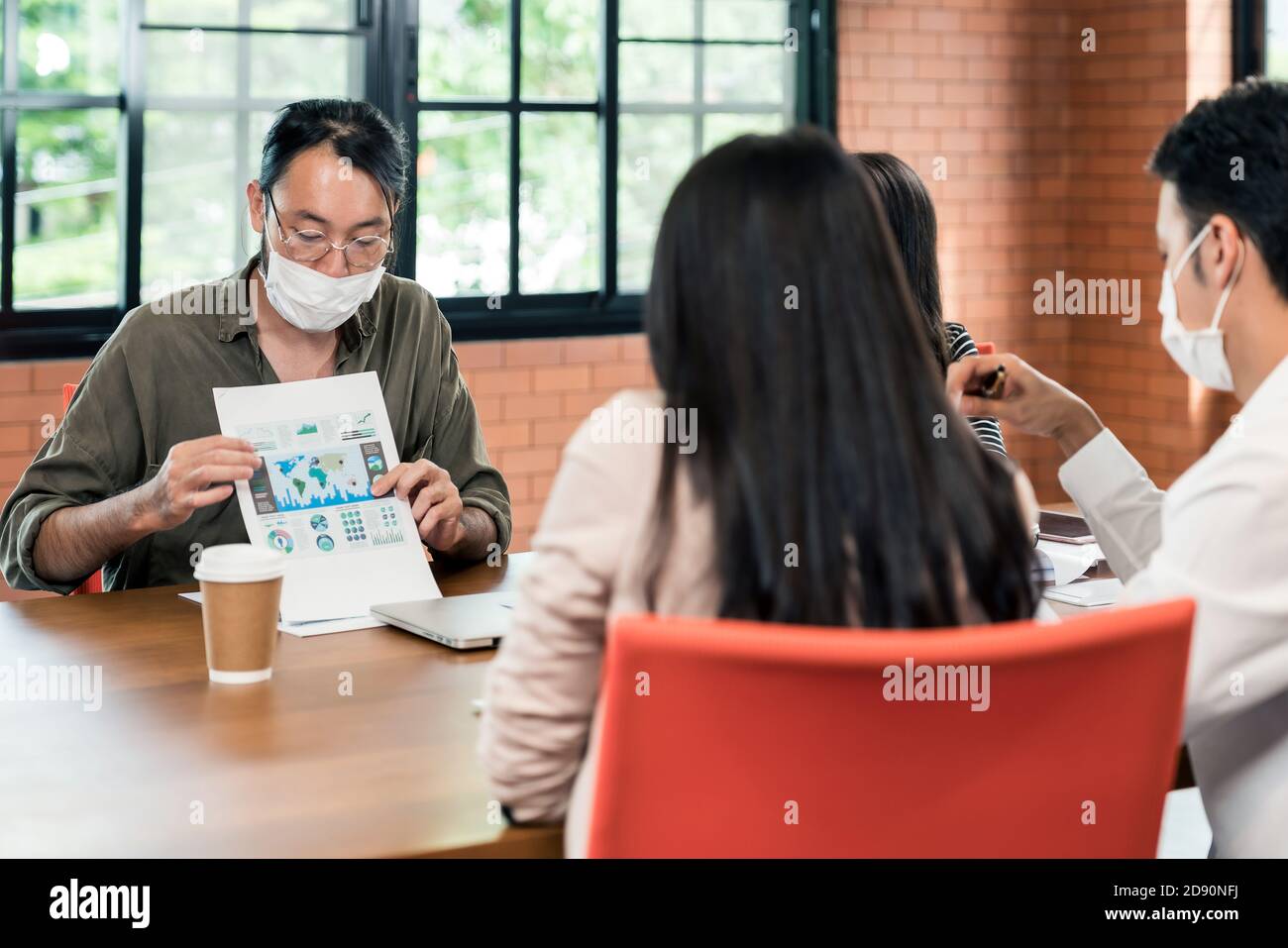 Group of asian and caucasian business person team meeting and brainstorm in meeting room after office reopen, they wear protective face mask as new no Stock Photo