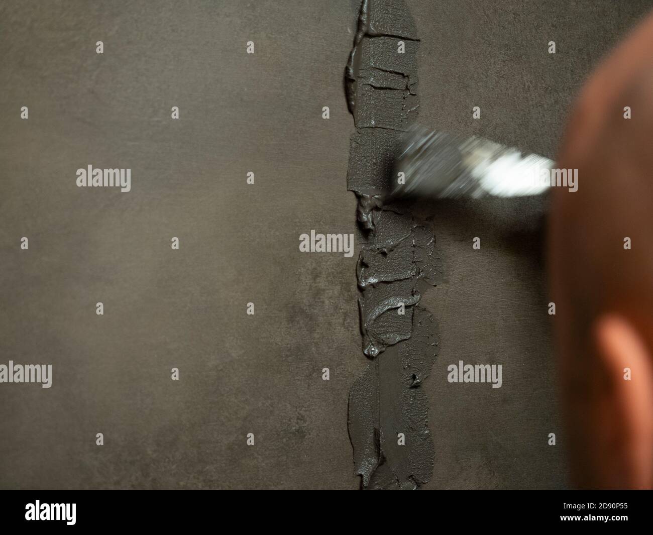 worker putty shower on construction site for renovation Stock Photo