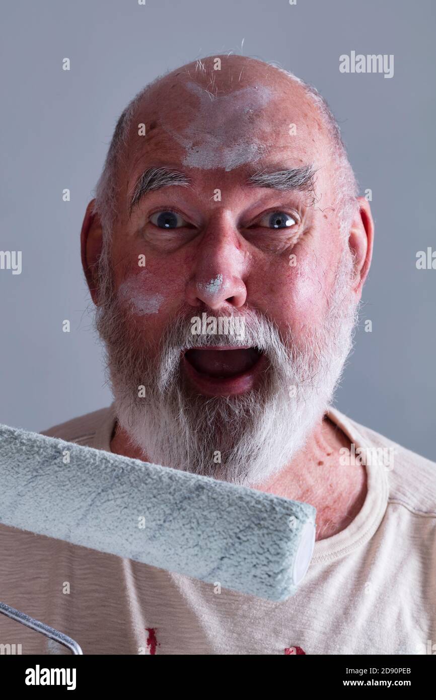 Senior man looking really happy, having just finished painting a room. Stock Photo