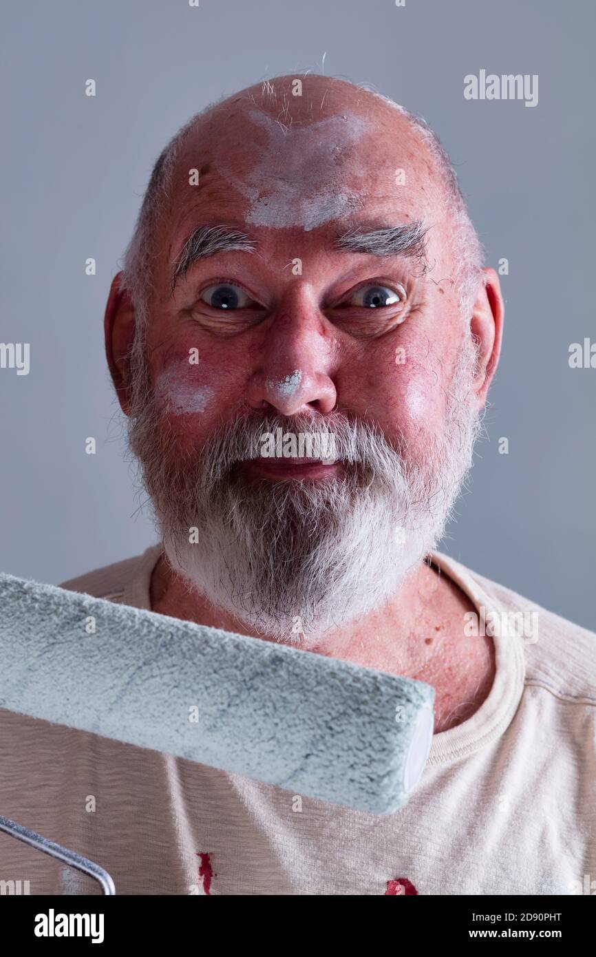 Senior man looking really happy, having just finished painting a room. Stock Photo