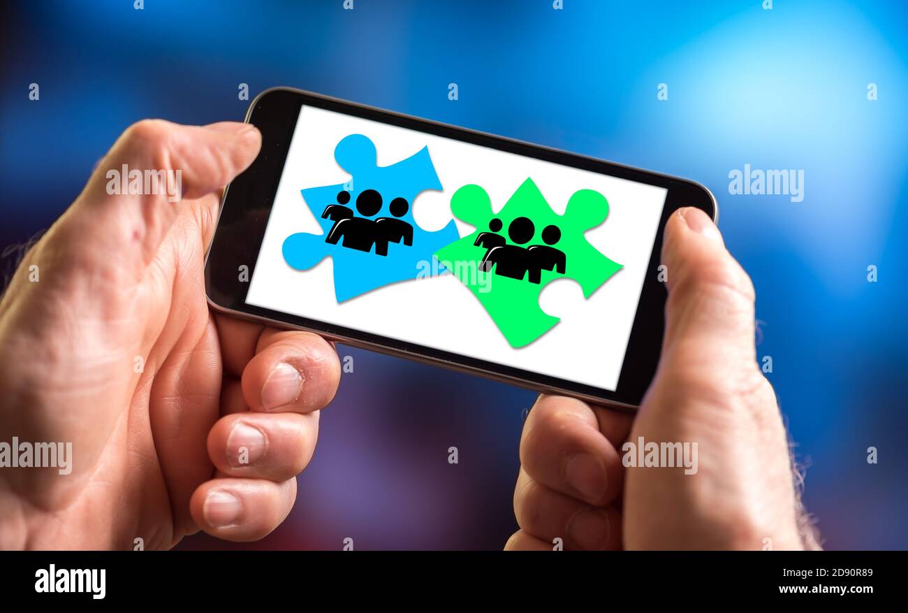 Hand holding a smartphone with teamwork concept Stock Photo - Alamy