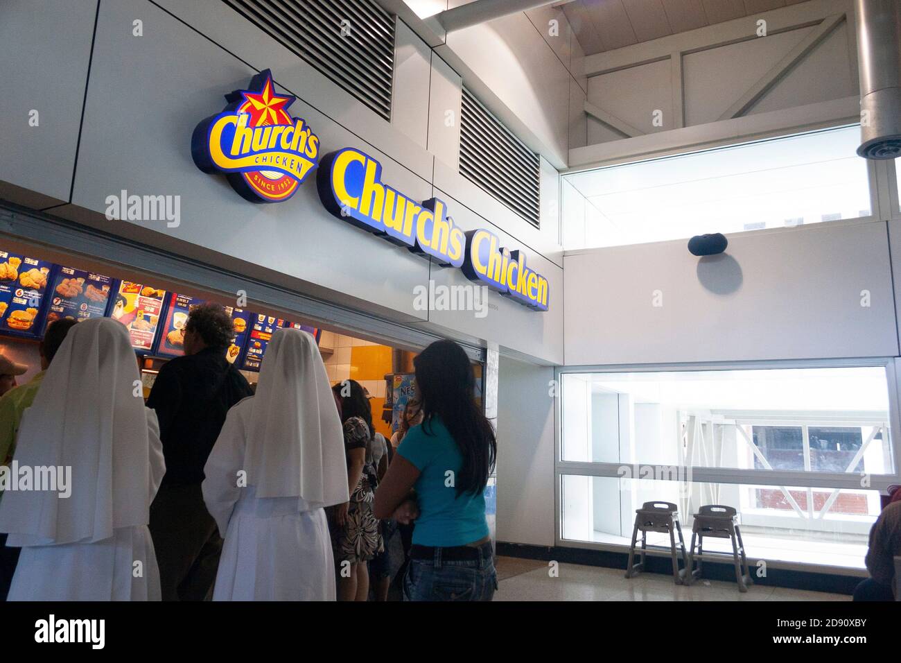 Nuns in funny places .Nuns waiting their turn to be served in a store chain of fast food Church's Chicken. Stock Photo