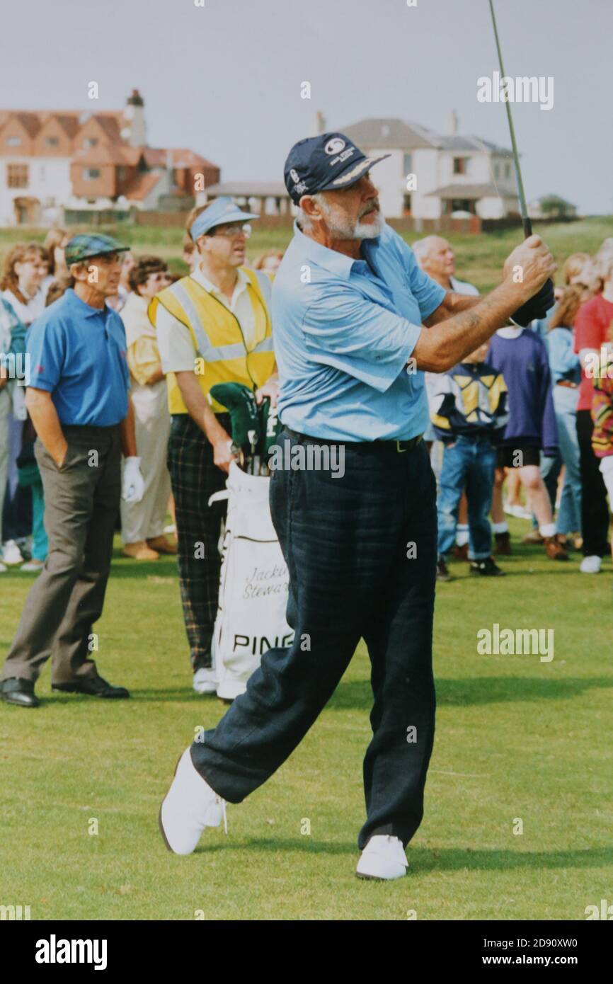 Prestwick, Ayrshire, Scotland, UK  :Late 1980s / early 1990's Sir Sean Connery ee offt at a Pro-am golf competiton held at Prestwick Old Course, the original course for the Open Golf championship. In the background can be seen Sir Jackie Stewart Stock Photo