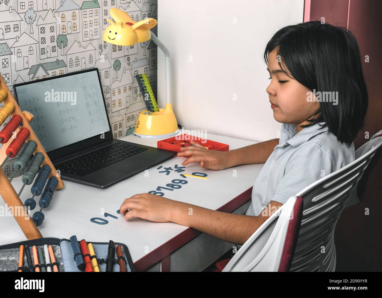 Asian schoolgirl studying homework math during her online lesson at
