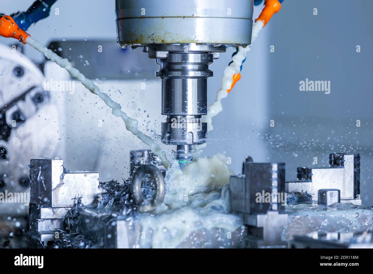 vertical cnc steel milling process with external water coolant streams,  splashes and a lot of metal chips, high contrast Stock Photo - Alamy