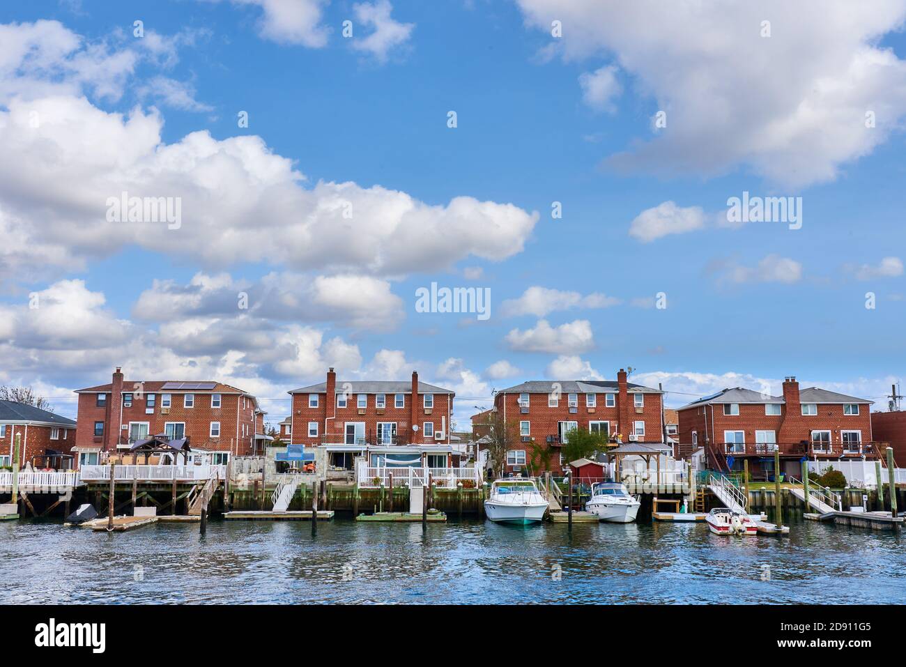 Three identical brick houses in a row with boat docks are a few of the