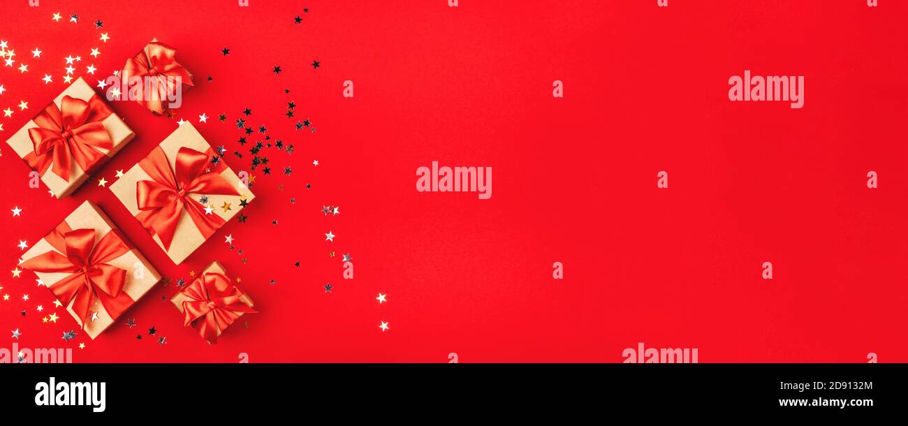 Several gift boxes with bows on a red background. Stock Photo