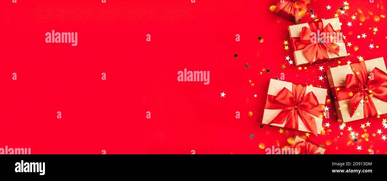 Several gift boxes with bows on a red background. Stock Photo