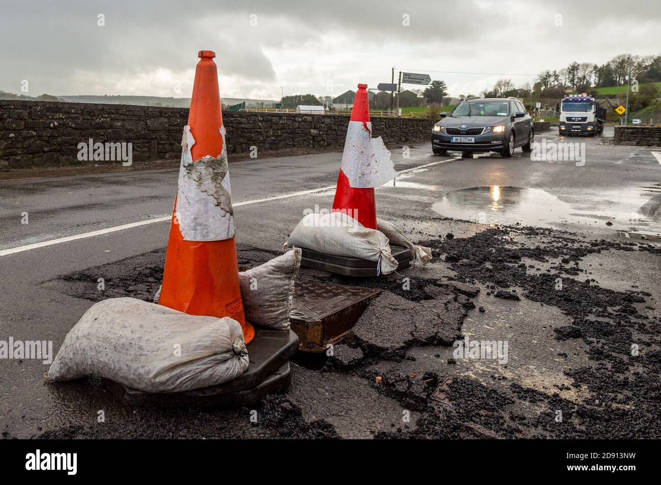 Timoleague, West Cork, Ireland. 2nd Nov, 2020. The road outside Timoleague National School was damaged overnight due to incessant, heavy rain after a Met Eireann Weather Warning. The council placed traffic cones to warn road users of the damage. Credit: AG News/Alamy Live News Stock Photo
