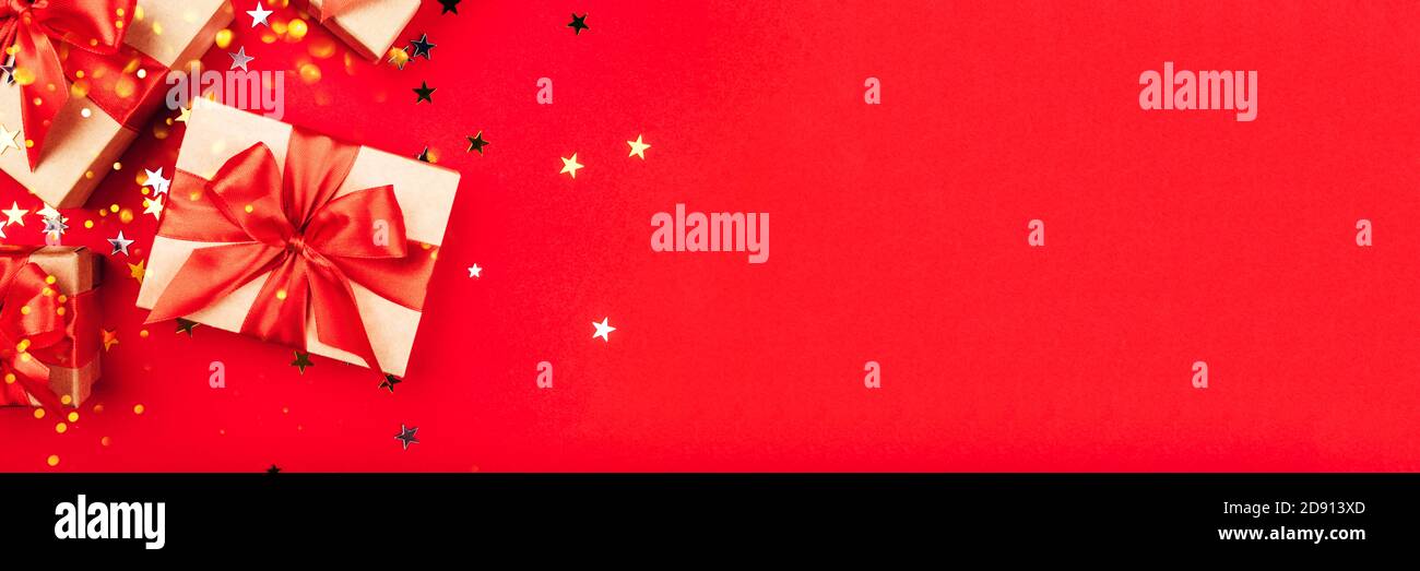 Several gift boxes with bows on a red background. Stock Photo