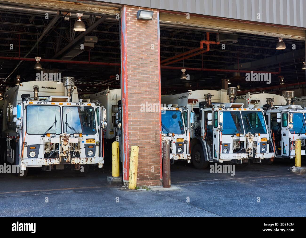 These sanitation Department garbage trucks are stored in a garage in Sunset Park, Brooklyn, NY, while not in use. Stock Photo