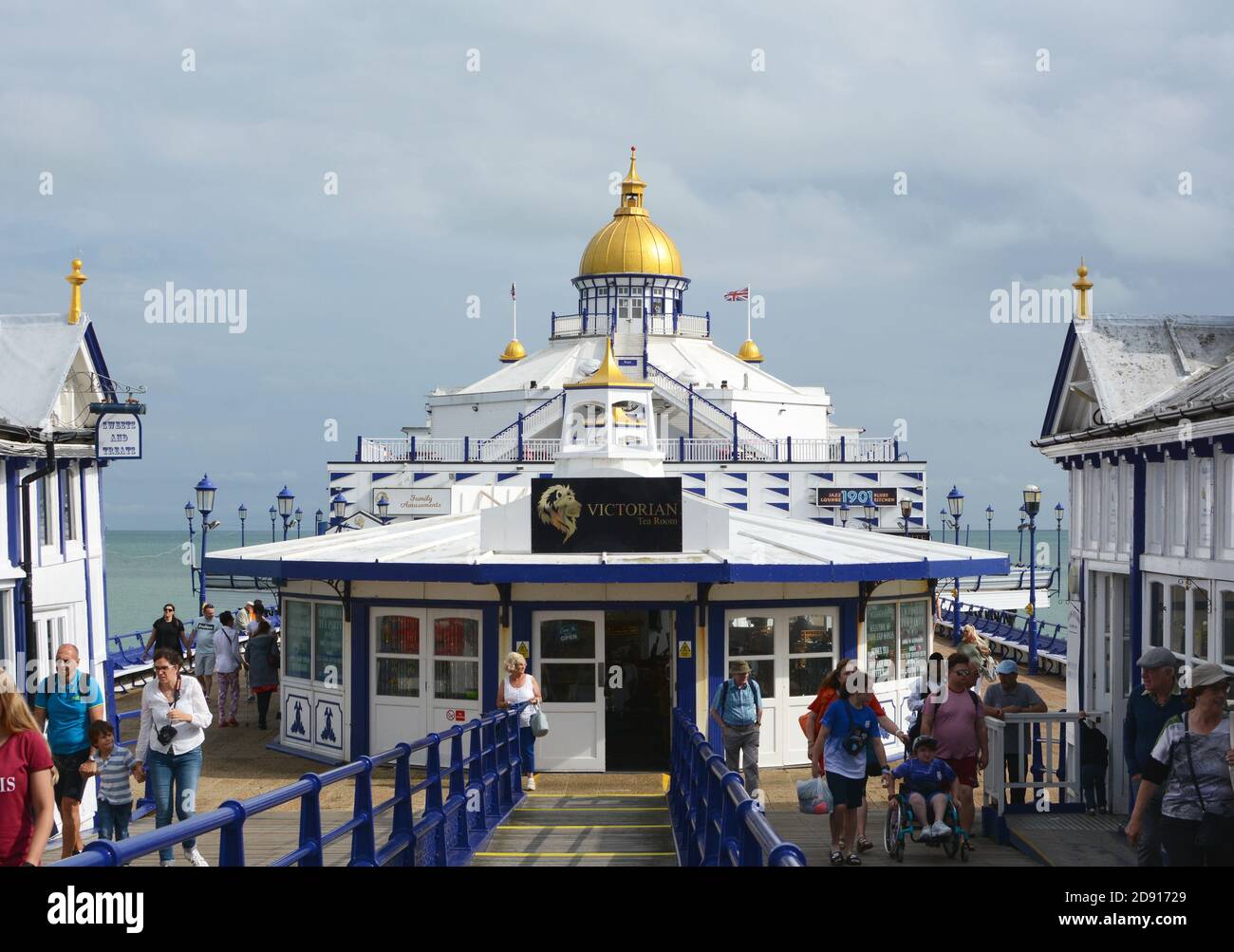 EASTBOURNE, UK - AUGUST 28, 2019: View down Eastbourne pier with tourists walking around the Victorian tea room in the centre of the deck on August 28 Stock Photo