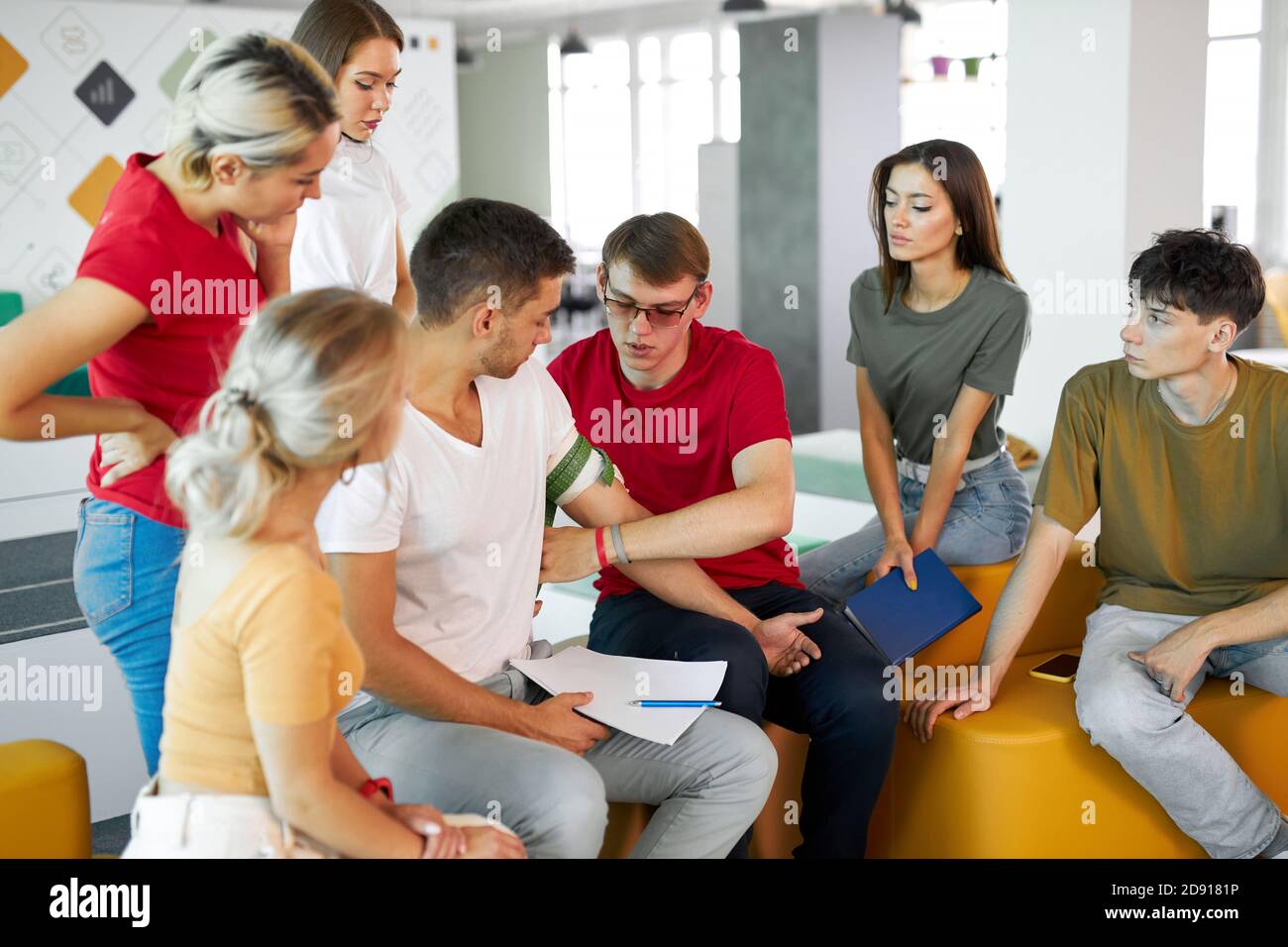 man wearing tourniquet on arm of injured person during class of giving