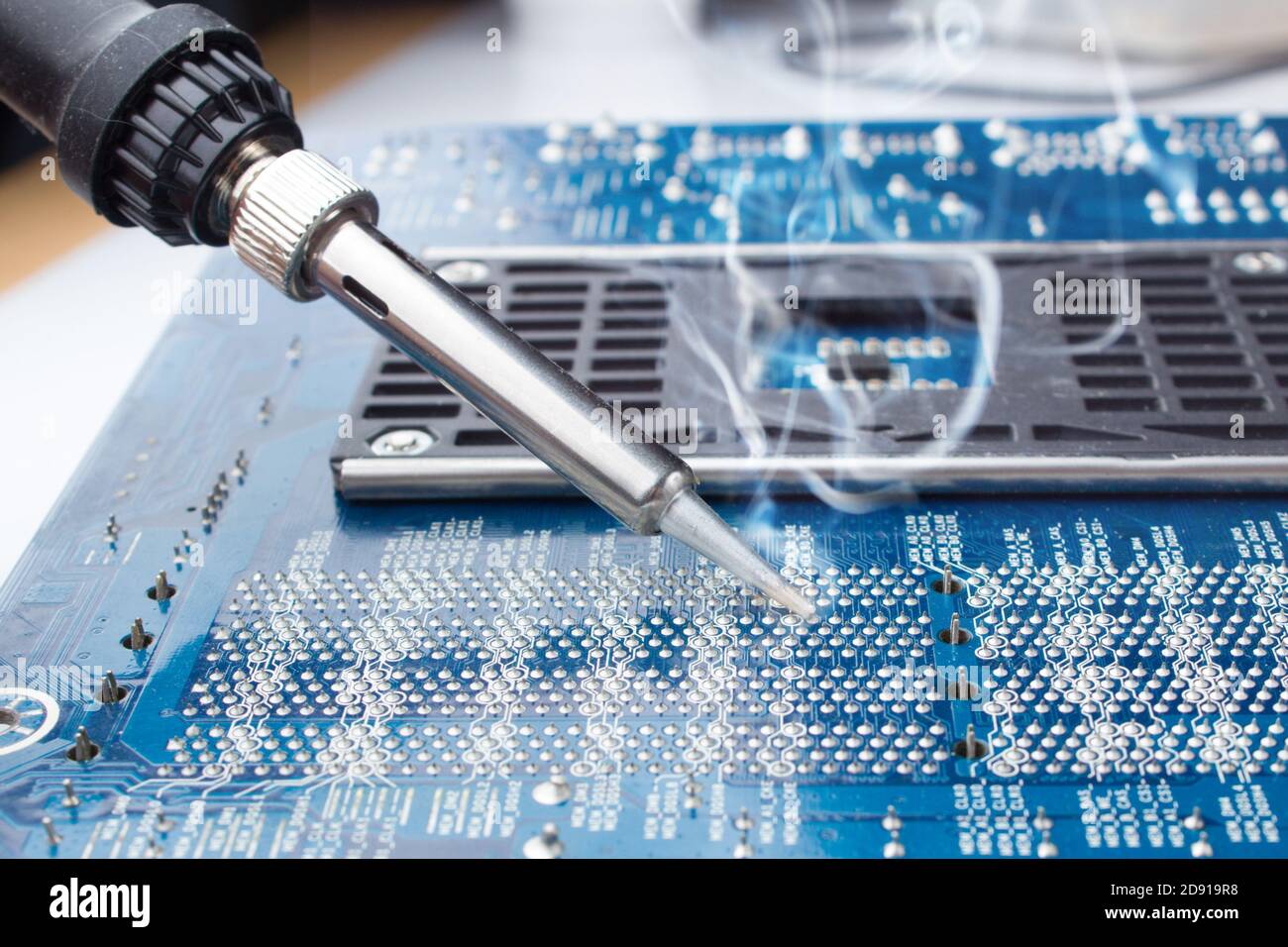 use a soldering iron to solder the electronic part to the Board. Computer repair. Macrophotography. Stock Photo