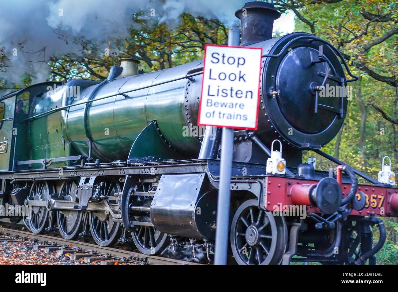 Vintage UK steam train passing Stop Look Listen danger sign on rural Severn Valley Heritage Railway line, UK. Stock Photo