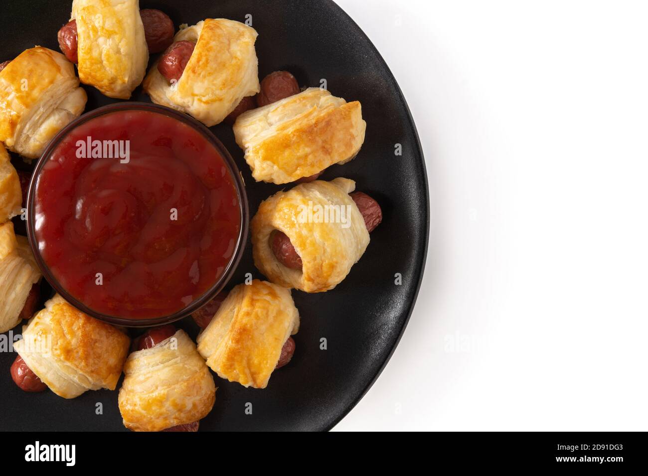 Pigs in blankets. Mini sausages wrapped in puff pastry with ketchup