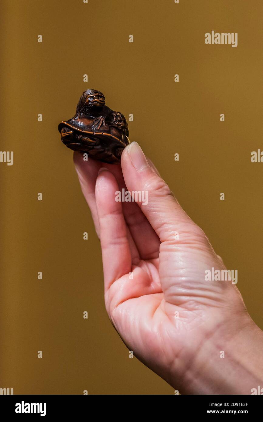 London, UK. 02nd Nov, 2020. A wood netsuke of a kappa on a tortoise By  Naito Toyomasa (1773-1856), Tanba Province, early 19th century, est £8,000  - 10,000 - Fine Netsuke from a