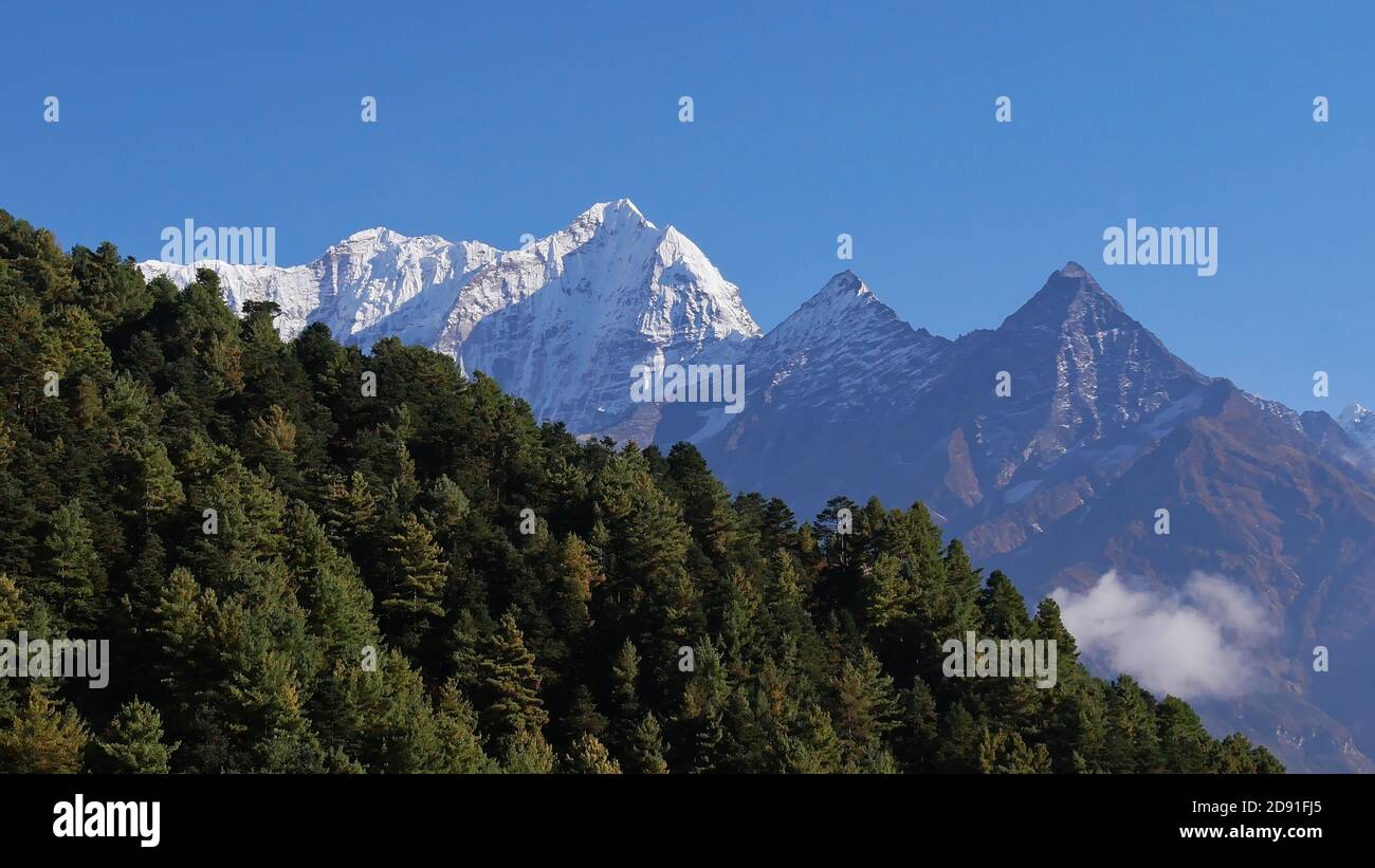 Majestic snow-capped mountain Kusum Kanguru (peak 6,367 m) in Hinku Himal east of Namche Bazar, Himalayas, Nepal with forest of coniferous trees. Stock Photo