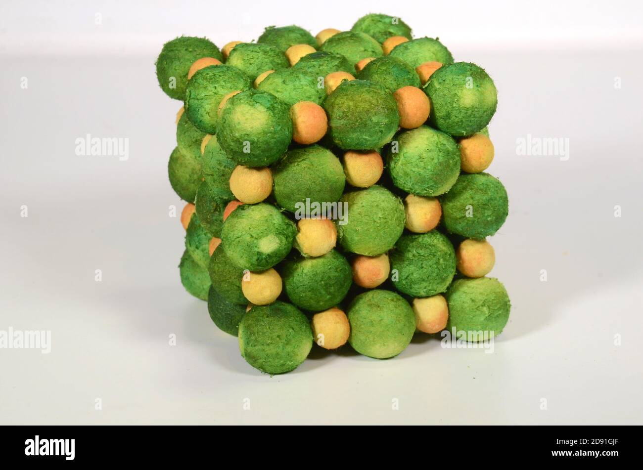 Atom model of a salt crystal, yellow is sodium, green is chlorine. Stock Photo