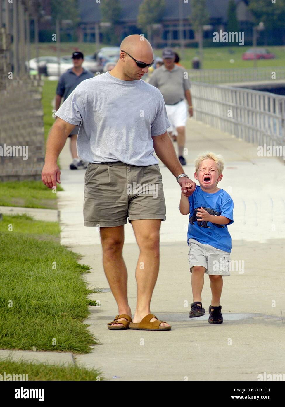 father walk with child toddler on a boardwalk one child is having temper tantrum angry outburst Stock Photo