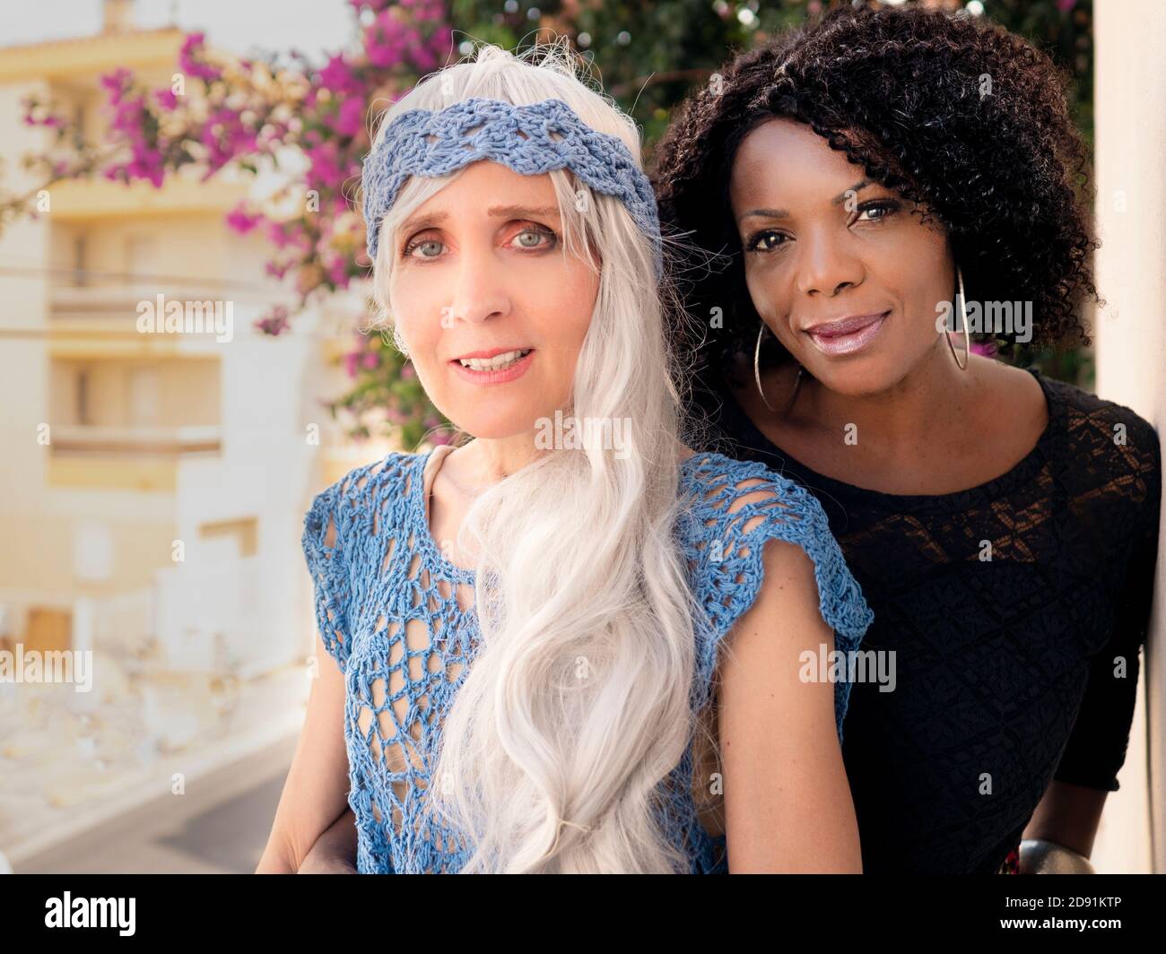 Horizontal portrait of two elegant and beautiful black and white women friends in summertime Stock Photo