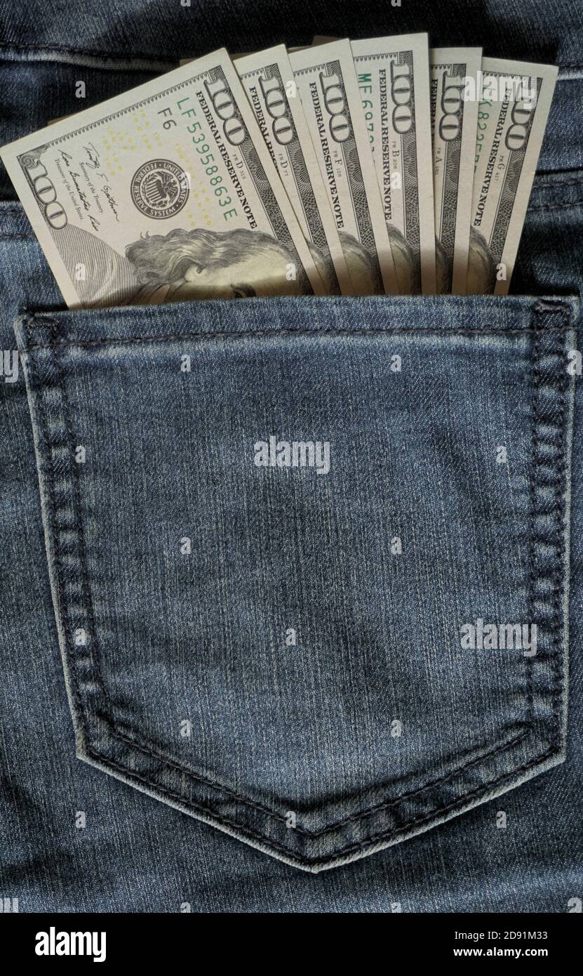 One hundred dollar banknote money in pocket jeans pants background texture. 100 dollar bill close up. Corruption. Stock Photo