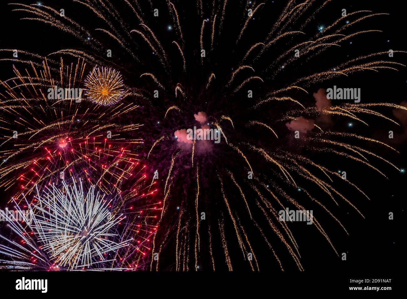 Looking up at fireworks exploding against a night sky Stock Photo